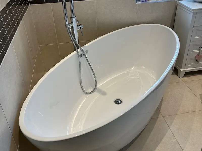Freestanding bath with a chrome floor-standing tap, fitted by our plumbers